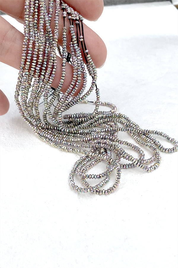 Hematite (button cut) Silver Aurora finish Size: Approx. 1.2 x 2.5 mm Hole diameter: Approx. 0.5 to 0.6 mm