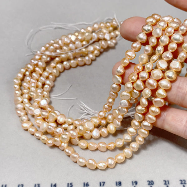 【淡水パール】 （フラットポテト） ナチュラルオレンジ 大きさ　約5.5～6×6.5～7.5mm 穴径　約0.5mm 約52～54個　約33cm